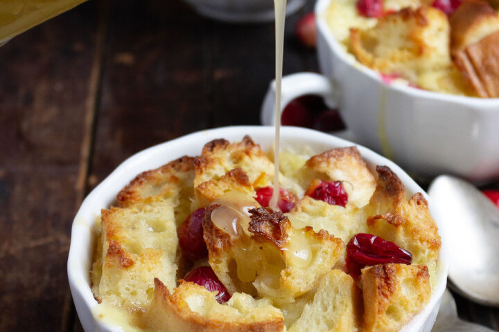 cranberry orange bread pudding with butter sauce being poured