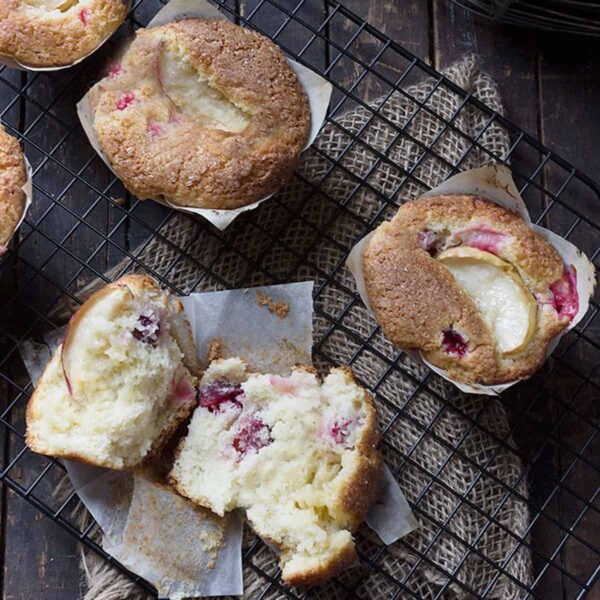 cranberry vanilla muffins split open on cooling rack