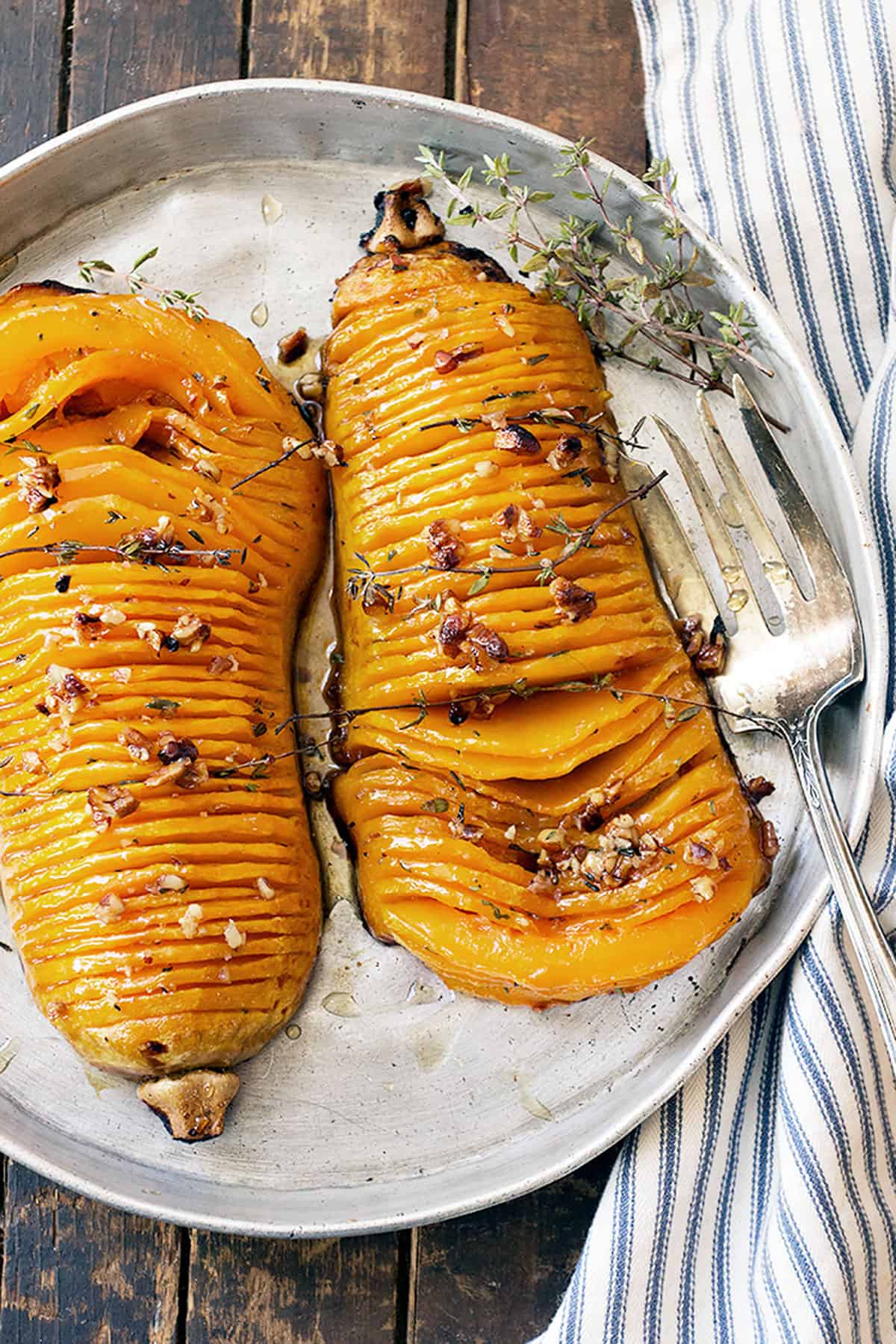 hasselback butternut squash on serving platter with fork