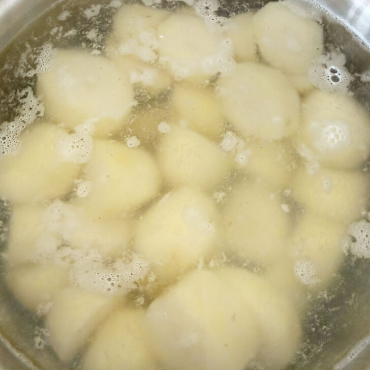 Potatoes boiling in a large pot.