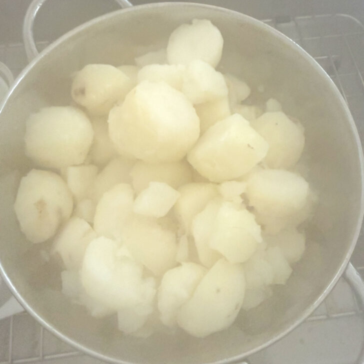 Cooked potatoes drained in a colander.