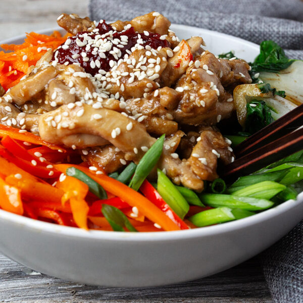 chicken bibimbap in bowl with rice and vegetables