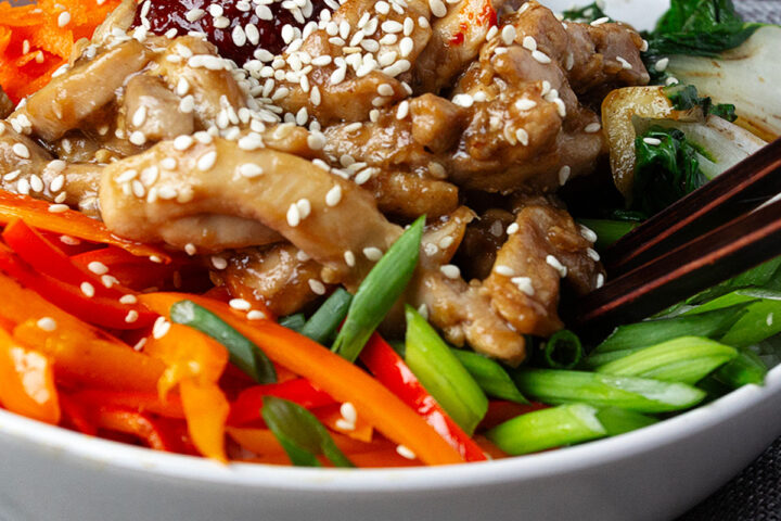 chicken bibimbap in bowl with rice and vegetables