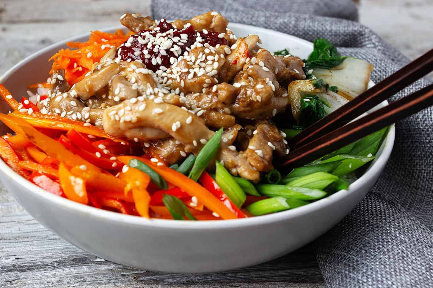 chicken bibimbap in bowl with rice and vegetables