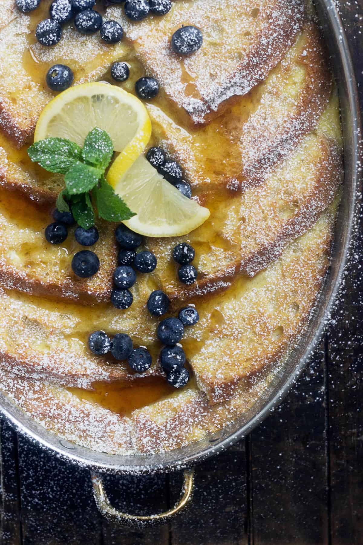 lemon French toast in baking dish with blueberries and lemon slices