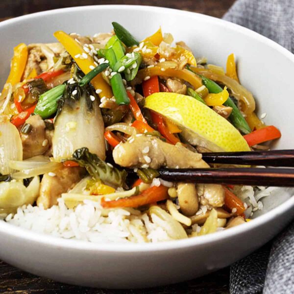 lemon chicken stir fry in bowl with rice and chopsticks