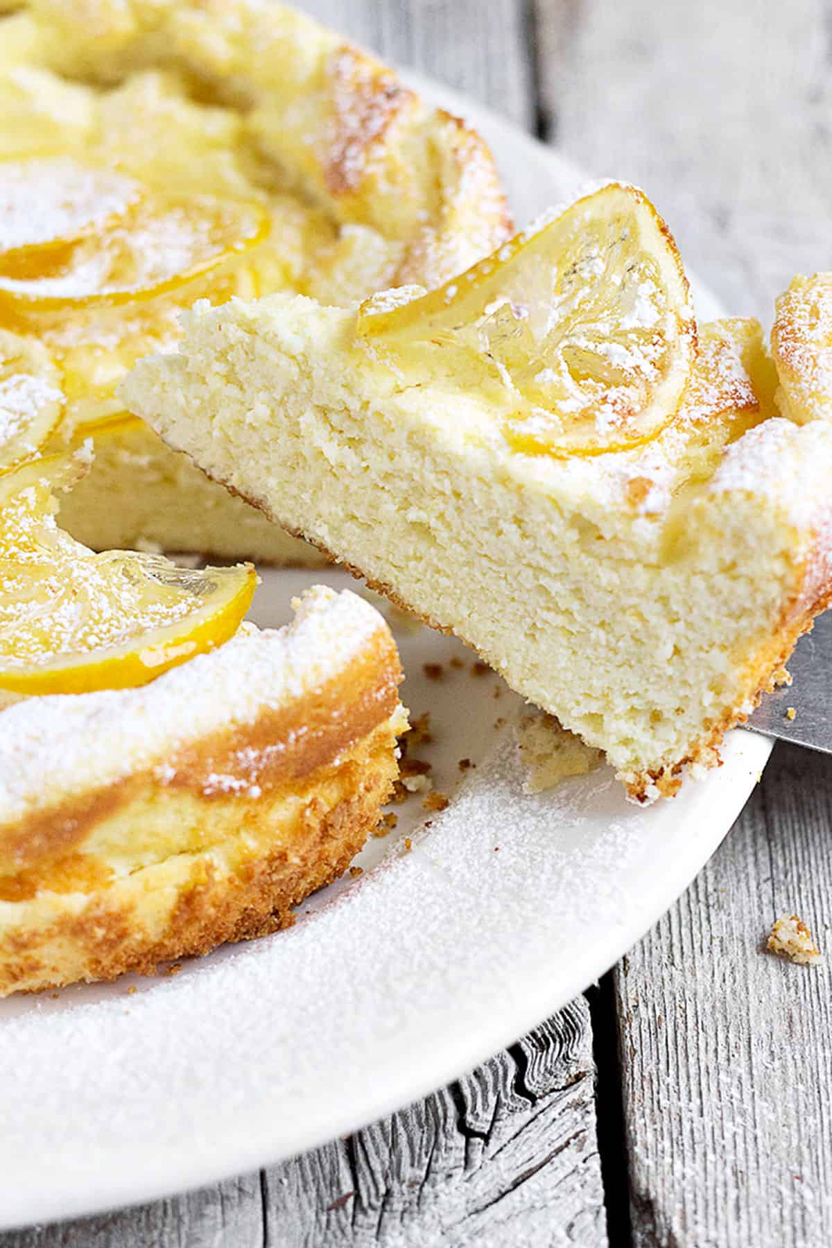 lemon ricotta cake sliced on white plate