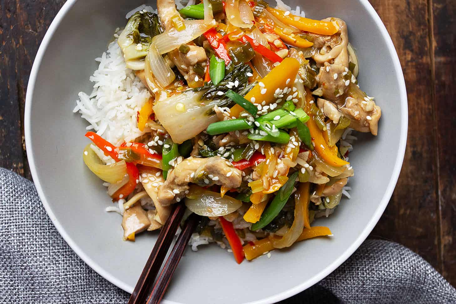 lemon chicken stir fry in bowl with rice and chopsticks