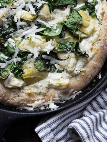 spinach artichoke pizza in skillet