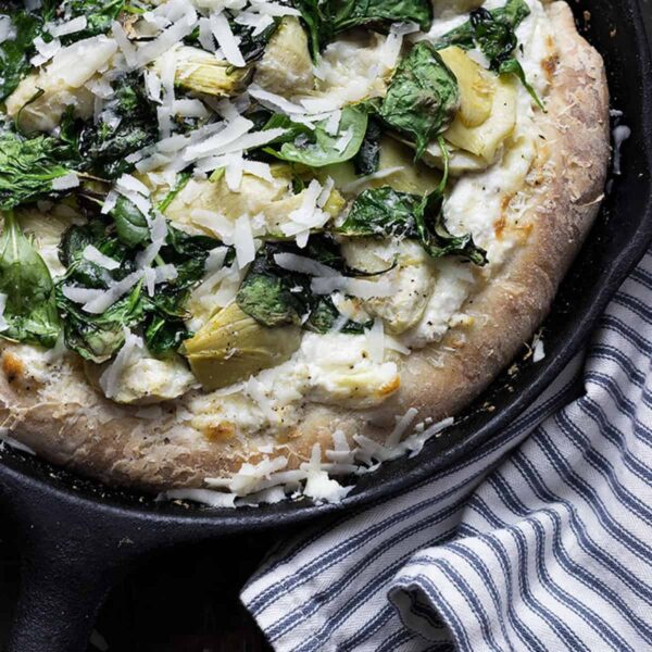 spinach artichoke pizza in skillet