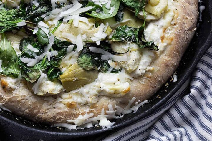 spinach artichoke pizza in skillet