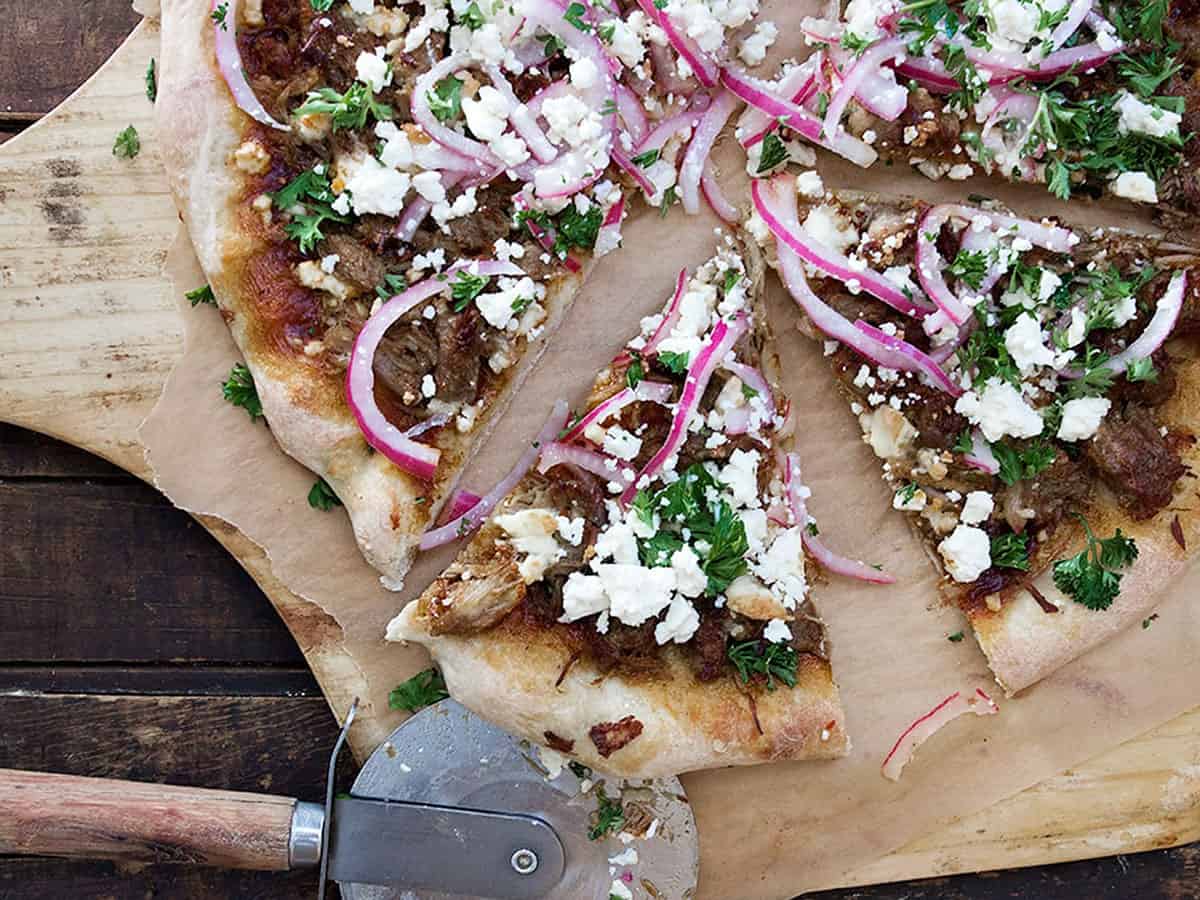 carnitas pizza sliced on pizza peel