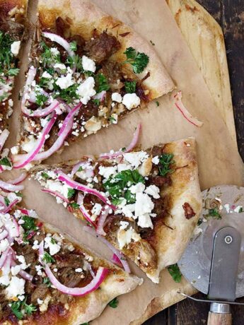 carnitas pizza sliced on pizza peel