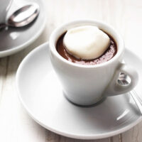 chocolate pudding shots in espresso cups with whipped cream on top