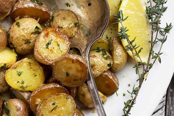 lemon garlic potatoes in white bowl with spoon