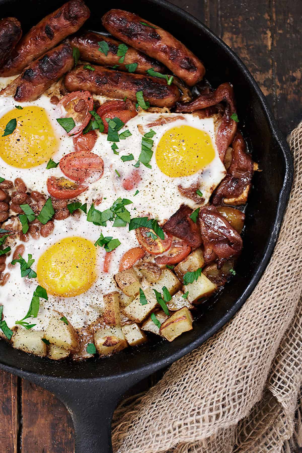 breakfast skillet in cast iron skillet with eggs potatoes and sausage