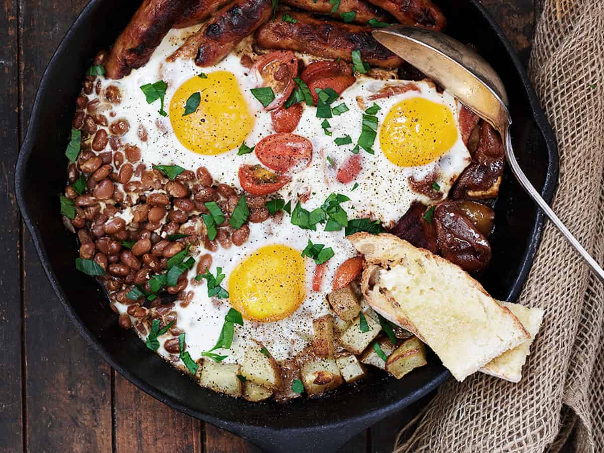 breakfast skillet in cast iron skillet with eggs potatoes and sausage