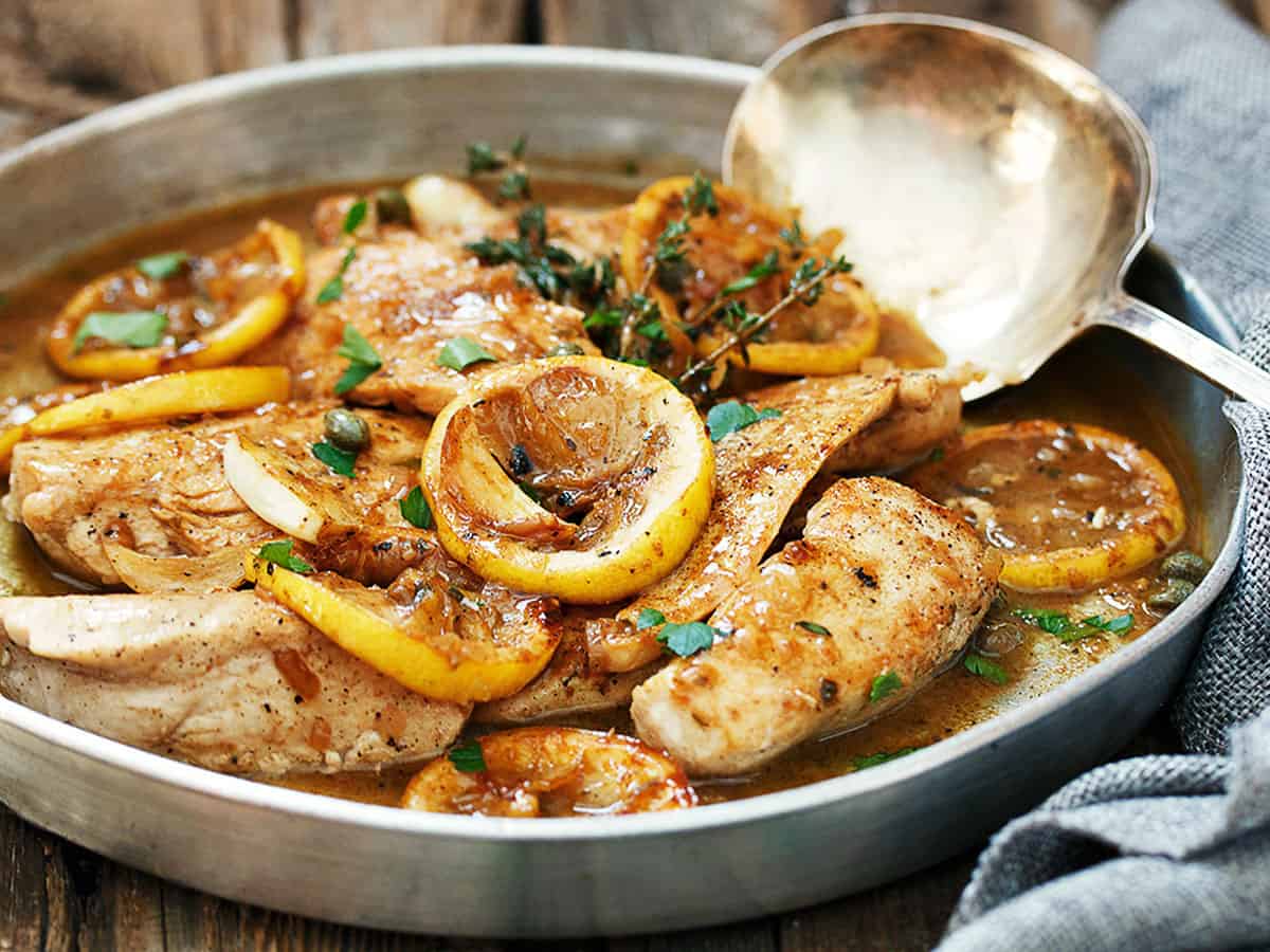 charred lemon chicken in pan with spoon