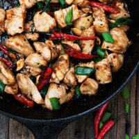 kung pao chicken in cast iron skillet with peppers