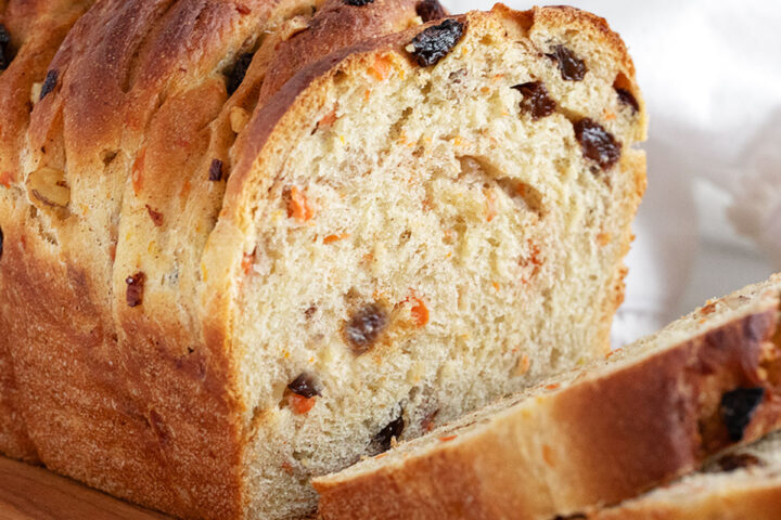 Carrot raisin yeast bread sliced on a cutting board.