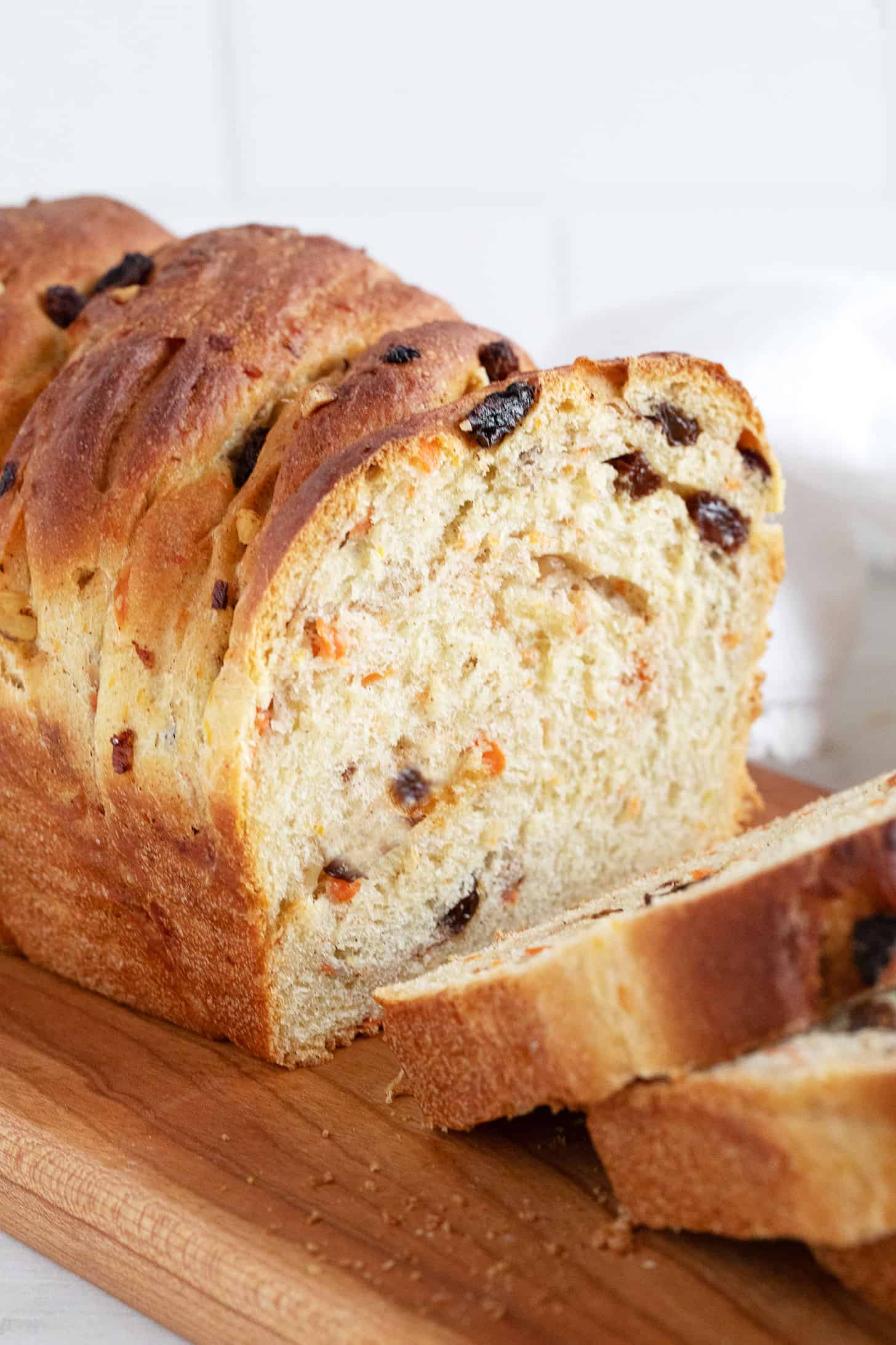 Carrot raisin yeast bread sliced on a cutting board.