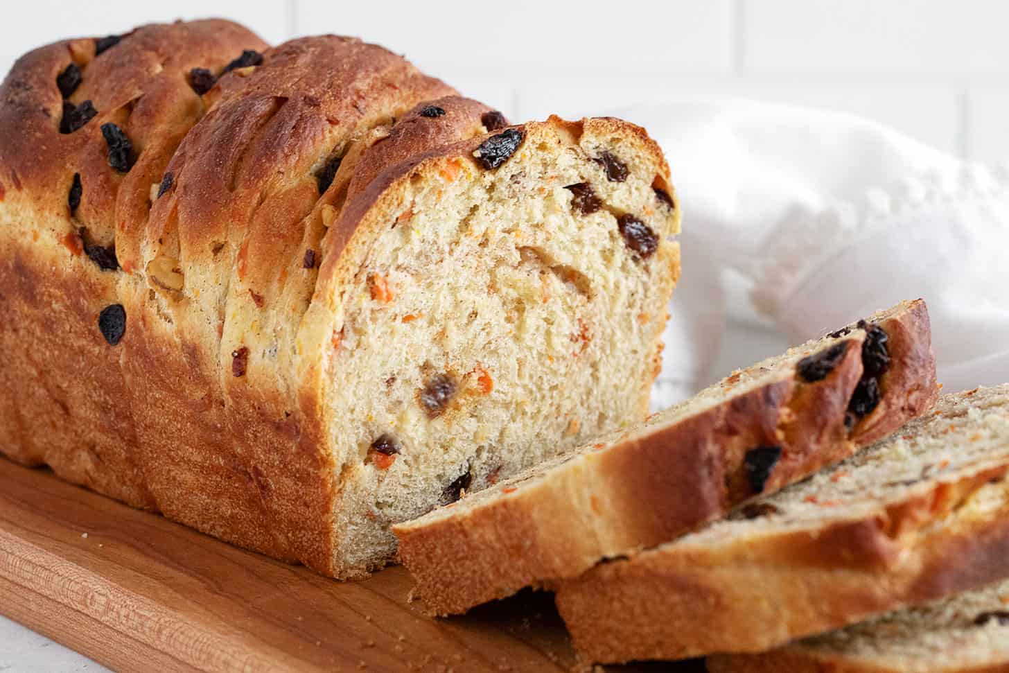 Carrot raisin yeast bread sliced on a cutting board.