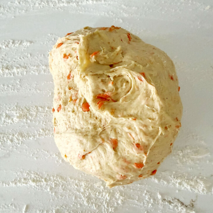 Carrot raisin bread dough on a work surface.