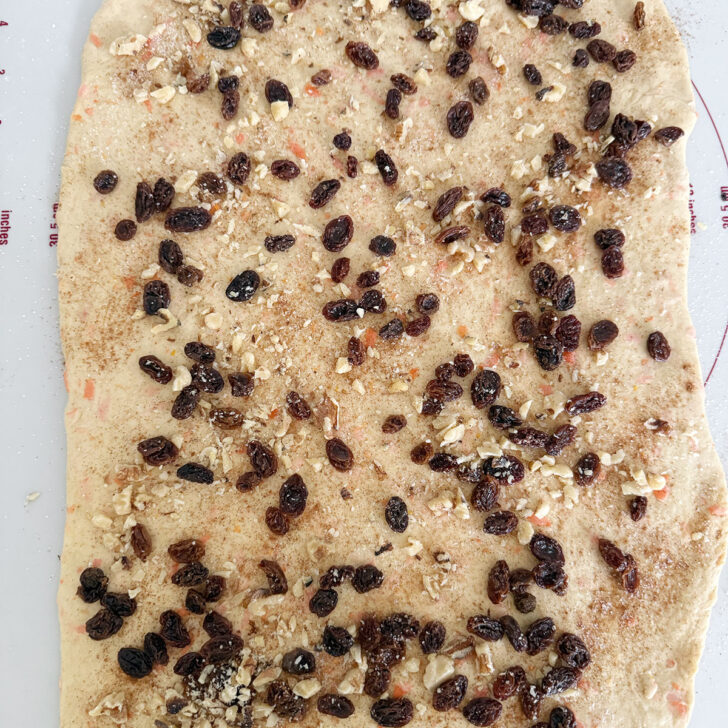 Dough sprinkled with raisins and walnuts.
