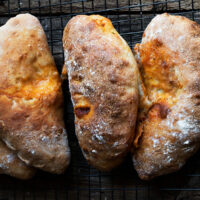 calzones lined up on dark background