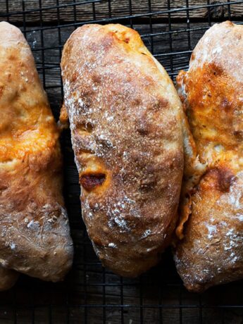 calzones lined up on dark background