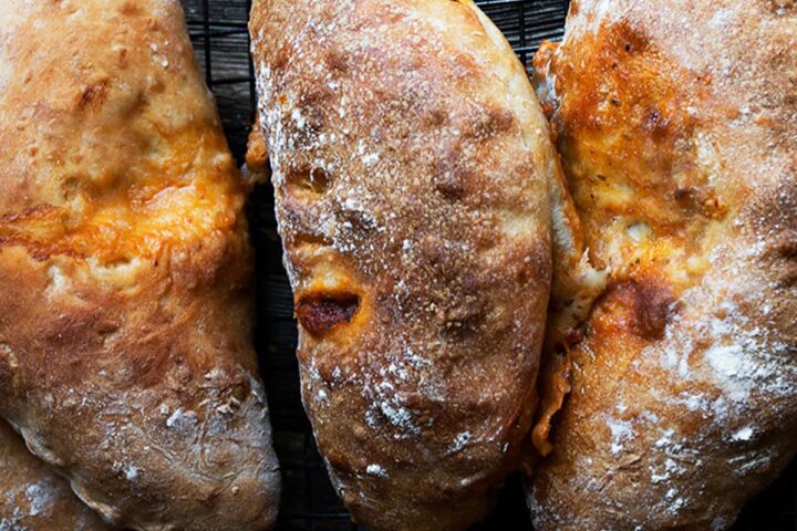 calzones lined up on dark background