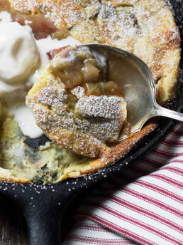 rhubarb Dutch baby in skillet with spoon