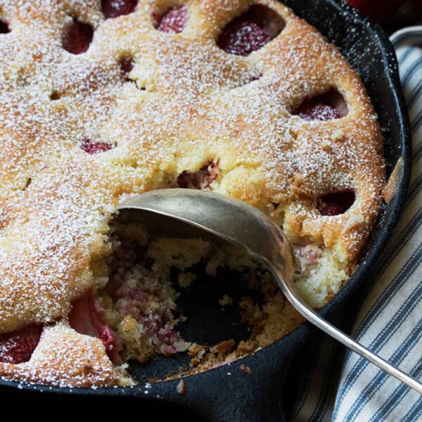 strawberry buttermilk cake in skillet with spoon