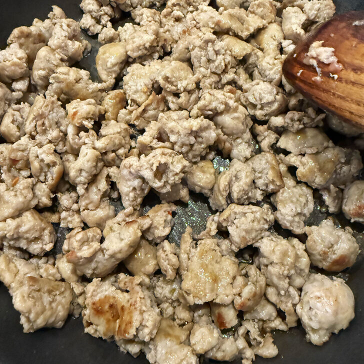 Sausage crumbles cooking in a skillet.