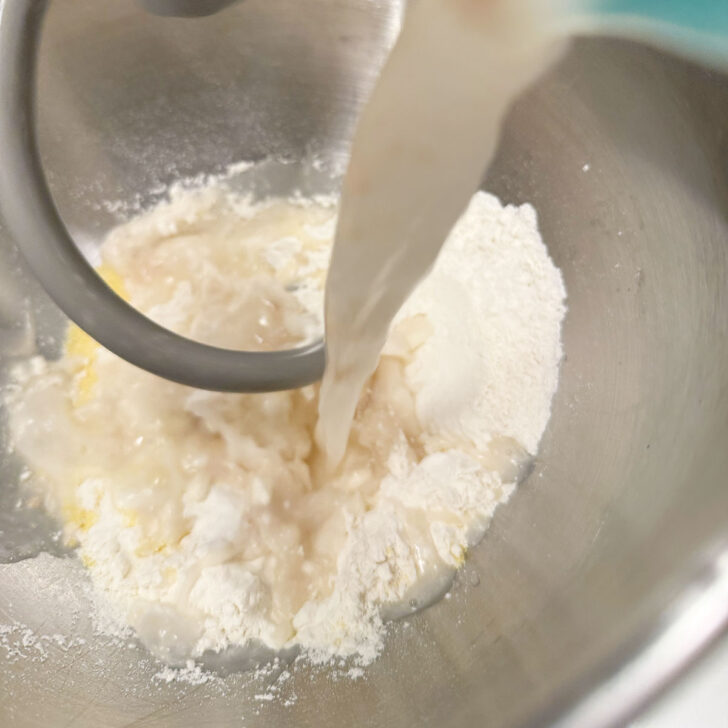 Adding the proofed yeast to the flour and cornmeal.