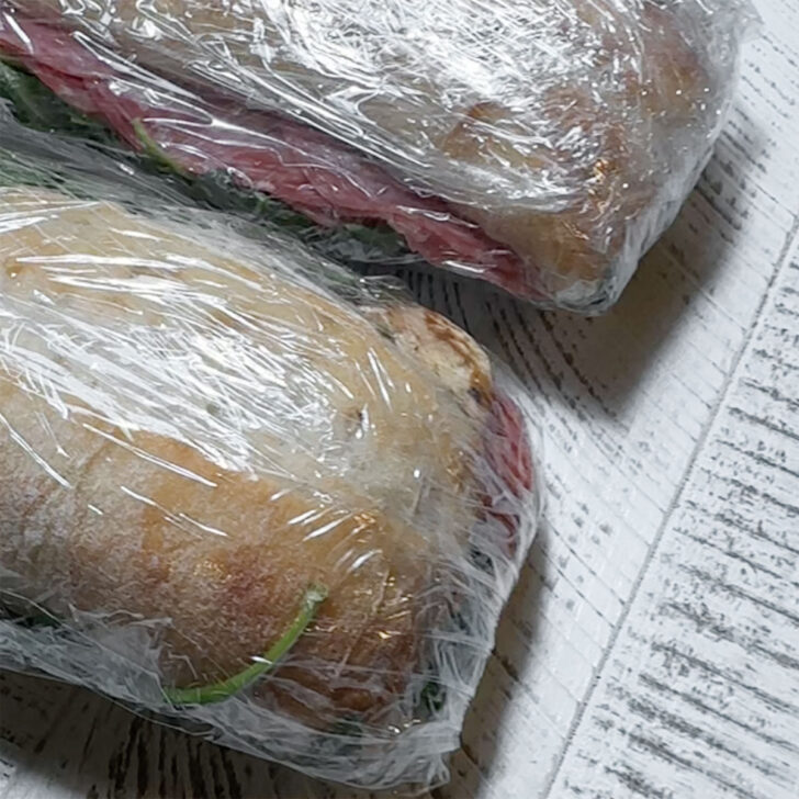 Filled sandwiches wrapped tightly with plastic wrap.