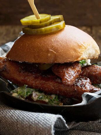 nashville hot chicken sandwich on platter with pickles