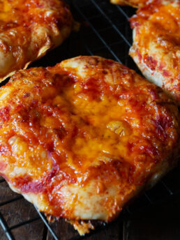 Pizza buns cooling on a wire rack.