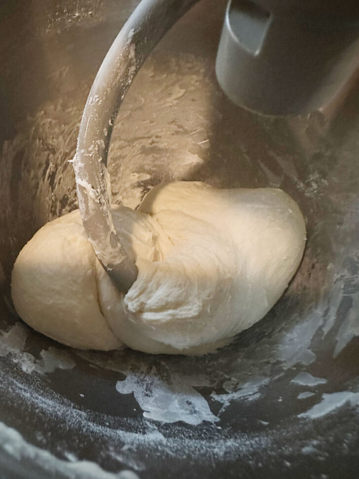 Making the pizza buns dough in a mixer bowl.