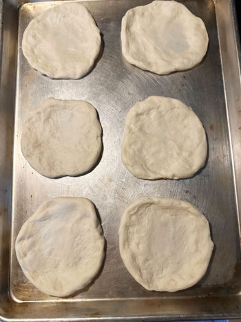 stretched dough pieces on baking sheet