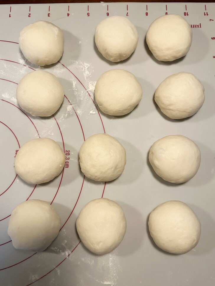 Pizza buns dough formed into 12 balls.