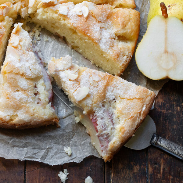 French pear cake sliced on parchment paper