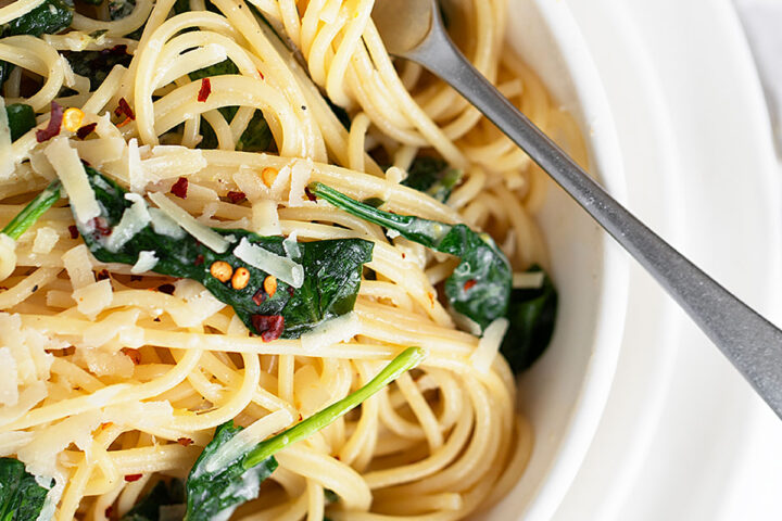 Lemon spinach pasta in bowl with fork.
