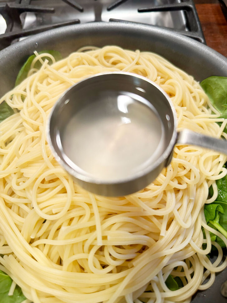 Adding pasta-cooking water to skillet.