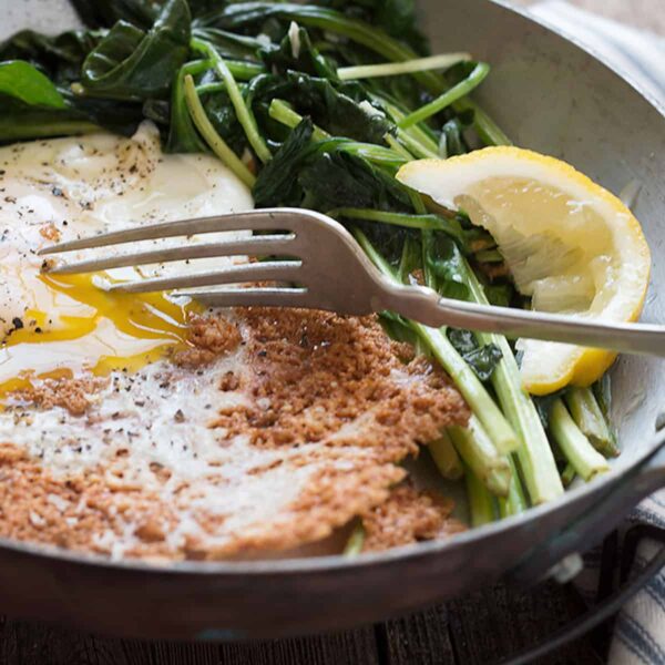 parmesan fried egg in skillet with spinach