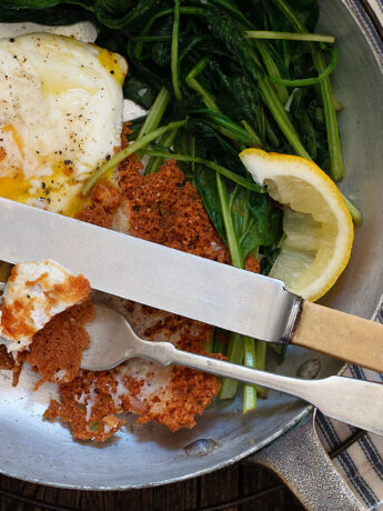 crispy Parmesan eggs in skillet with spinach