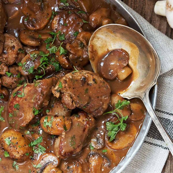 pork medallions with mushrooms and marsala sauce in pan