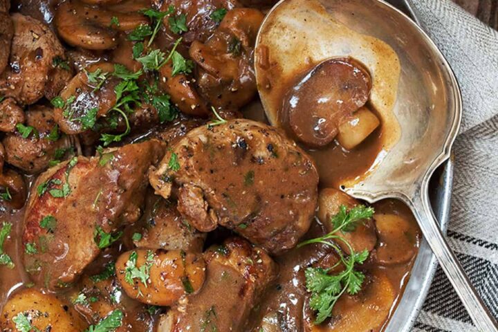 pork medallions with mushrooms and marsala sauce in pan