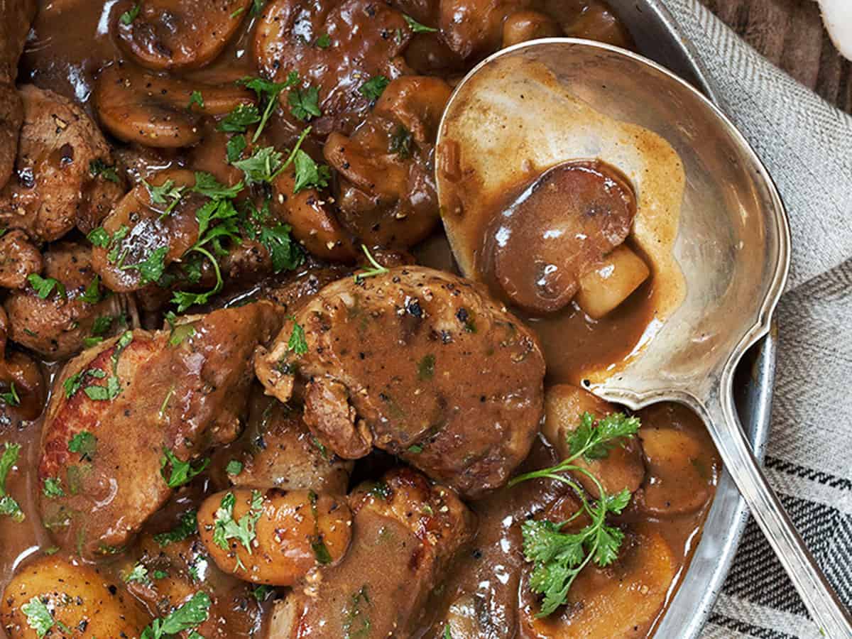 pork medallions with mushrooms and marsala sauce in pan