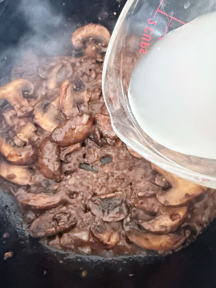 Adding chicken broth to the skillet.